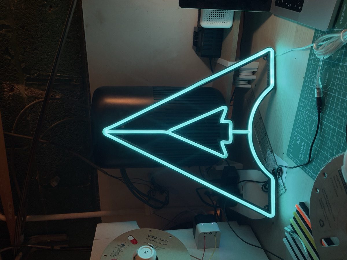 Néon LED avion en papier cyan turquoise sur fond sombre — WOAW Light